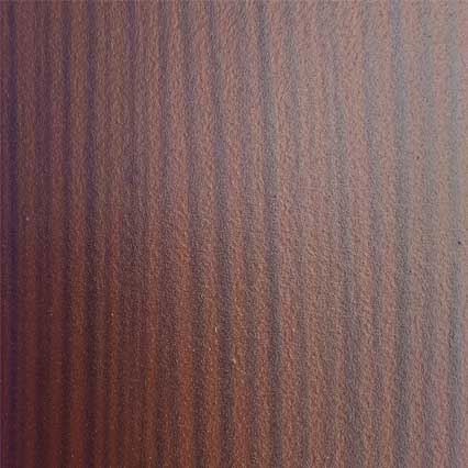 A close-up view of wood grain showing rich brown tones with darker and lighter streaks running vertically through the natural wood pattern.
