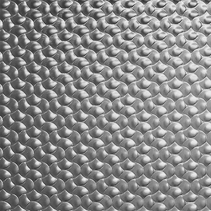 A repeating pattern of interlocking metallic scales or chain mail links creates a textured surface with dimensional depth and silvery gray coloring.